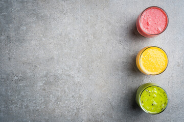 Glasses of fresh juice on gray stone table