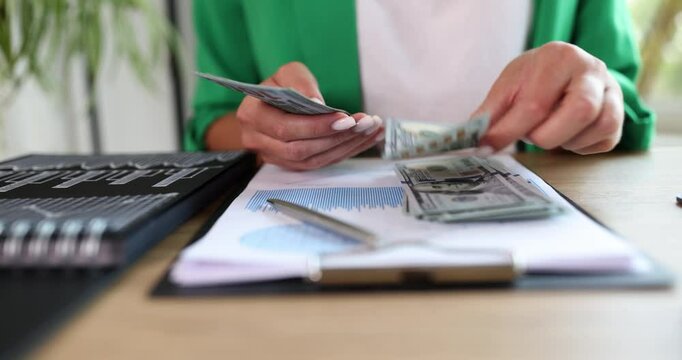 Business Woman in the office counts dollars, hands close-up. The concept of receiving profits, dividends from funds