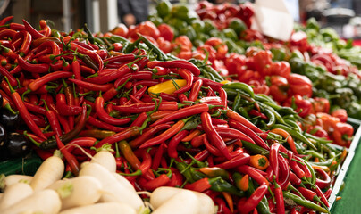 A heap of chili peppers on a market stall, Haagse Market in The Hague, Netherlands. Outdoors, spice, ingredients, hot and vegetables.