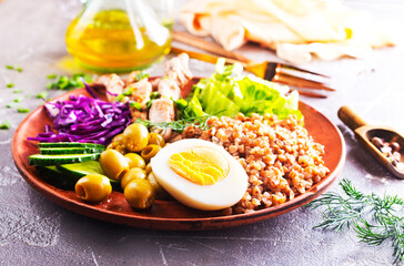 Roast pork with buckwheat groats with vegetables served on brown plate