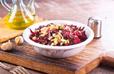 beetroot salad with walnut in a plate on dark background