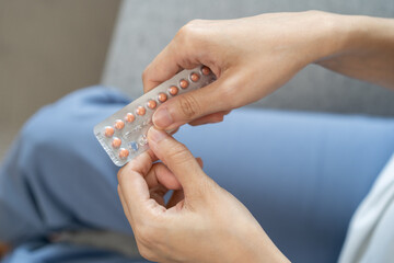 Contraception and pregnancy concept asian young woman hand open birth control pills, holding hormonal oral contraceptive medicine from blister pack, take pharmaceutical to prevention virus sex disease