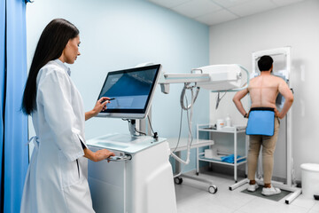 Female radiologist is making an Xray of lungs of patient in X-ray room of modern clinic. Doctor...