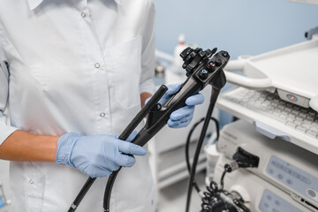 Cropped shot of instruments for diagnostic endoscopy close-up. The female doctor holds a flexible...