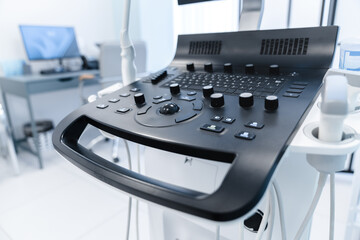 Close up of modern medical equipment in a bright light office. Apparatus for ultrasound diagnostics. Interior of hospital room with ultrasound machine and examination table in modern clinic