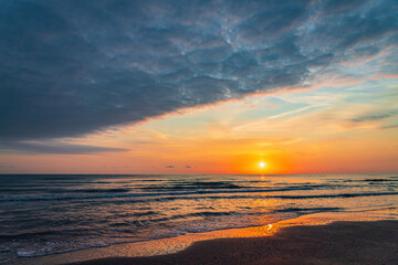 Colorful sunrise on the sea sandy beach