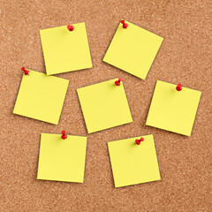 Yellow Sticky Notes on Corkboard with Red Push Pins