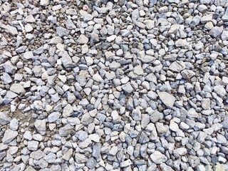 Different sizes of gravel spread across a construction site during daylight