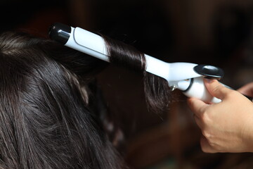 Fototapeta premium A person using a hair dryer to style their hair at home
