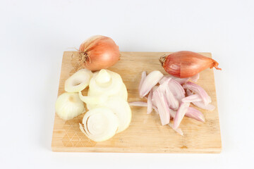 onions and shallots on a wooden chopping board 