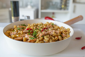 Homemade salmon with butter, garlic pasta in a pan on kitchen counter
