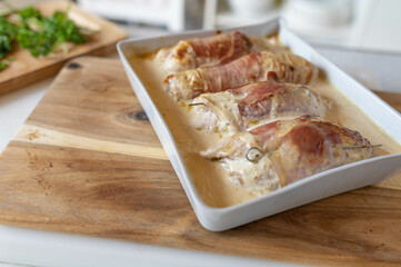 Delicious turkey roulades fille with cream cheese and wrapped up mit parma ham in a casserole dish. Homemade food