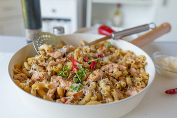 Salmon with pasta and parmesan chesse in  delicious garlic butter. Served ready to eat in a skillet. Homemade food