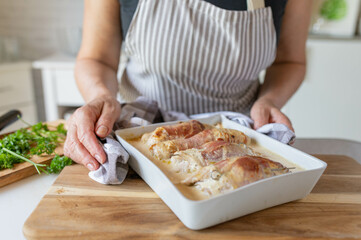 Fresh and homemade cooked poultry roulades served by woman´s hands for dinner on kitchen counter