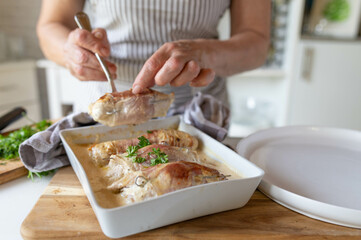 Fresh and homemade cooked poultry roulades served by woman´s hands for dinner on kitchen counter