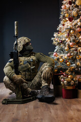the soldier in uniform looks at the Christmas tree