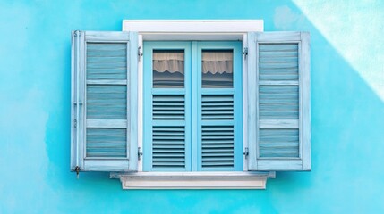 A charming blue window with shutters against a turquoise wall.