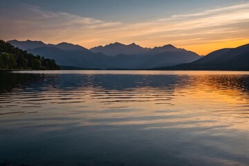 Fototapeta premium Calm, reflective lake at sunset, with gentle ripples on the water and mountains silhouetted in the background