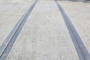 Fototapeta premium Industrial Concrete Surface with Metal Expansion Joints, A Close-Up Perspective