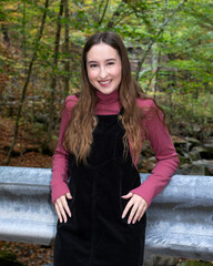 A smiling young woman in the fall colors