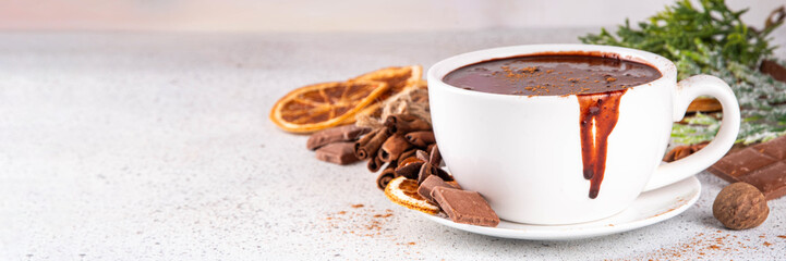 Traditional christmas hot chocolate drink cup with dried orange, cinnamon, anise, spices and Christmas tree sprigs copy space