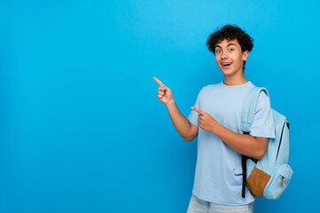 Smiling boy guy high school male pupil student teenager with dental braces backpack pointing index...