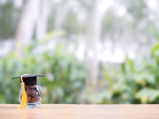 Glass bottle with graduation hat. The concept of saving money for education, student loan,...