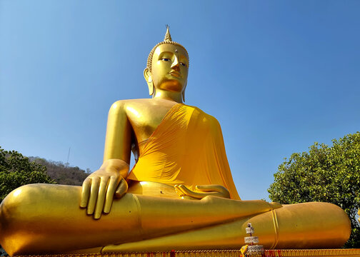 Pra Puttha Ariya Thammo Buddha on blue sky background: The Buddha statue on the hillside, a large and beautiful Marn Vichai style which is Sukhothai art at Wat Kao Plong temple, Chai Nat, Thailand.