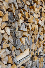 Background of stacked chopped wood logs. Pile of wood logs ready for winter. Wooden stumps, firewood stacked in heap