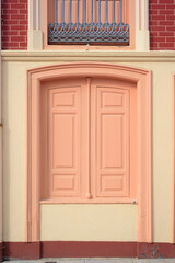 Puertas pintadas de rosa en fachada de edificio elegante en ciudad europea