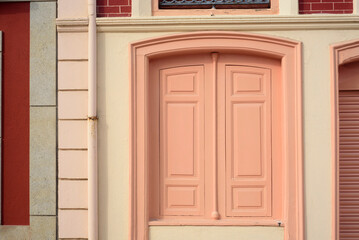 Puertas pintadas de rosa en fachada de edificio elegante en ciudad europea