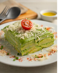 Baked potatoes with spinach bechamel and cheese.