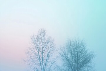 Two Bare Trees Silhouetted Against a Misty, Pastel Sky