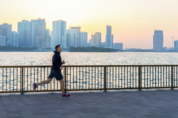 Mature man wearing sportswear running at riverside