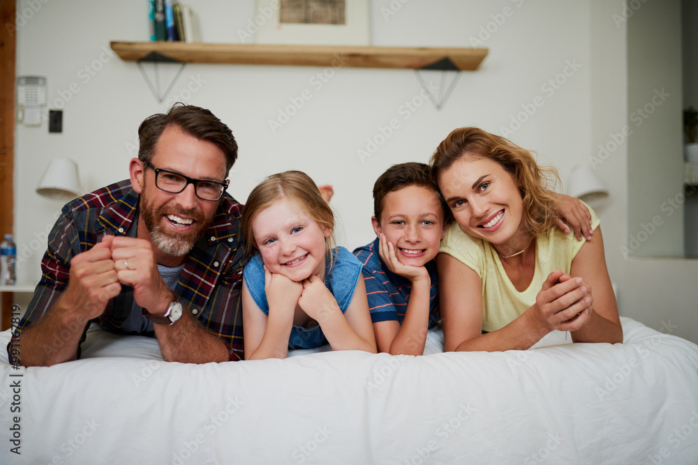 Wall mural Family, happy and portrait on bed for relax, support and bonding together in house with blanket. Parents, children and smile as people for comfort, love and weekend with hug, fun and face in home