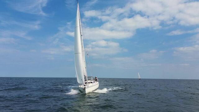  forward aerial drone 4K film of sailboat yacht sail sailing on sea ocean water with Dutch holland flag battling through waves