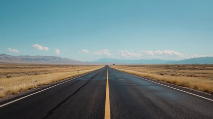 Endless Open Road Stretching Through Desert Landscape Under Clear Blue Sky