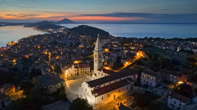 Mali Losinj old town after sunset with city lights. Aerial evening view of bays and islands of Croatia. Losinj and Cres islands - great summer sea travel destination
