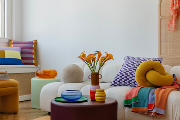 Colorful and cozy living room with vibrant cushions, a bold floral arrangement, and playful decor...