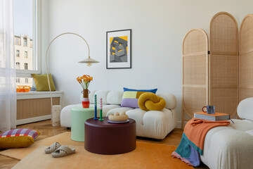 Bright and cozy living room with a white sofa, colorful pillows, and playful decor elements. A...