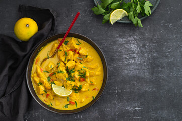 Bowl with chicken curry with vegetables on dark background. Indian cuisine. Thai Chicken Curry With Coconut Milk. Coconut. Thai Panang Curry. Top view, space for text. Food photography for restaurant
