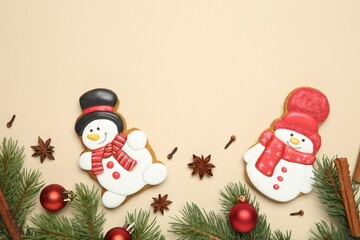 Flat lay composition with Christmas decor and delicious cookies in shape of snowmen on beige background, space for text