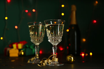 Glasses of sparkling wine on table against blurred lights