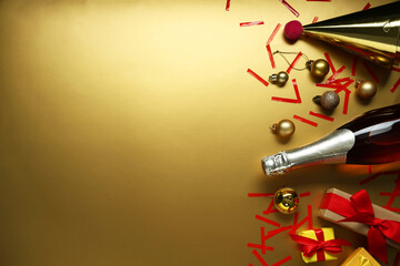 Flat lay composition with bottle of sparkling wine, confetti and other Christmas decor on beige...
