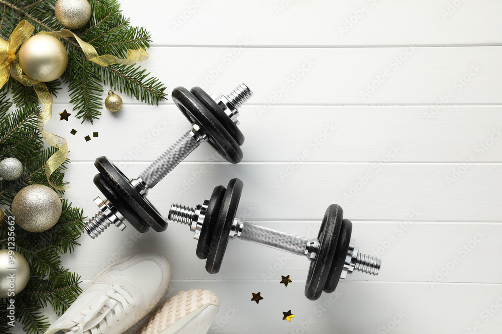 Poster Dumbbells, fir tree branches, sneakers and Christmas baubles on white wooden table, flat lay. Space for text