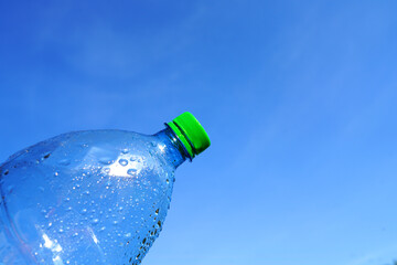 Plastic bottle on blue sky background. Plastic recycling and waste collection. Plastic sorting....