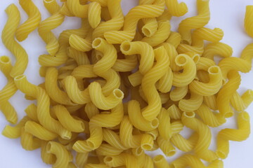 uncooked  macaroni on a white background
