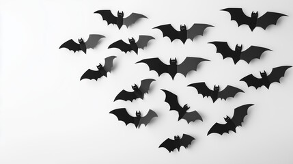 Fototapeta premium A collection of black bats arranged on a white background, designed in a paper cut-out style for a Halloween party. The flat lay composition emphasizes simplicity and elegance, making it an ideal dec