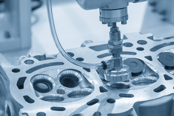 The intake and exhaust vale assembly process by robotic system in the light blue scene.
