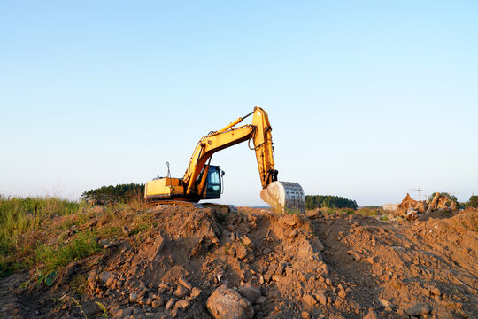 Excavator on groundwork. Excavator on earthmoving. Open-pit mining. Backhoe dig ground in quarry. Heavy construction equipment excavation on construction site. Road construction on construction site.